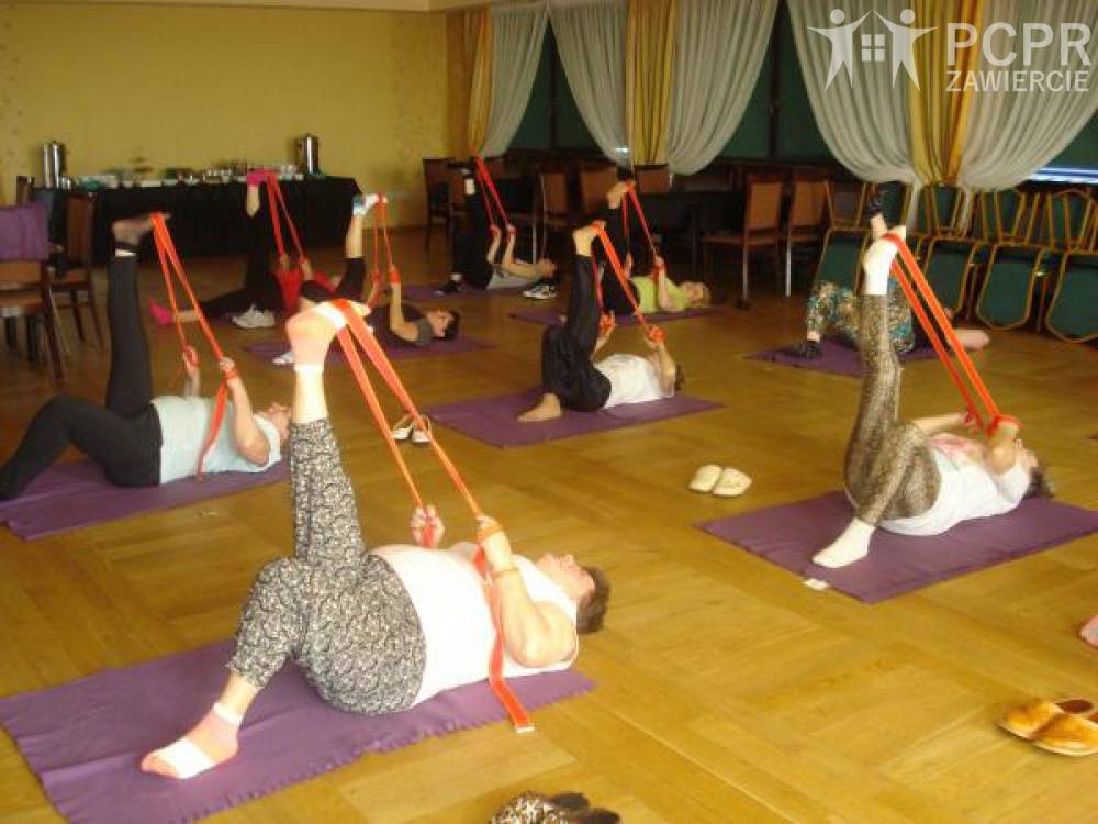 Zdjęcie: Grupa kobiet leżąc na matach na podłodze wykonuje ćwiczenia z taśmami